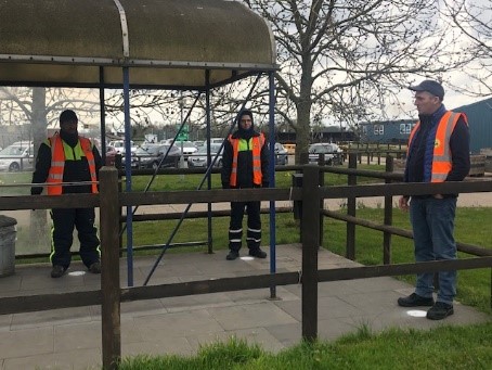a group of men standing by a metal fence